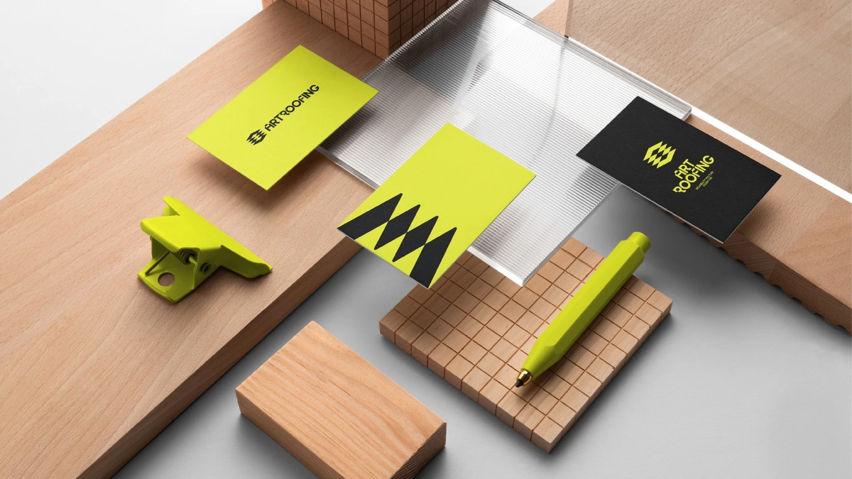 Art Roofing business cards in yellow and black beside a yellow pen
