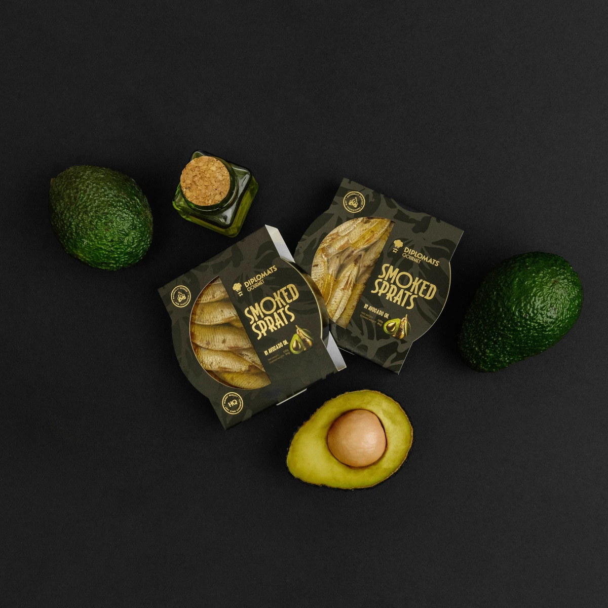 Two Smoked Sprats boxes overhead among avocados and oil bottle