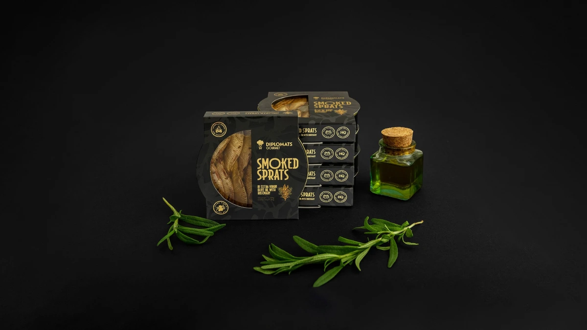 Diplomats Smoked Sprats boxes with olive oil bottle and rosemary on black background