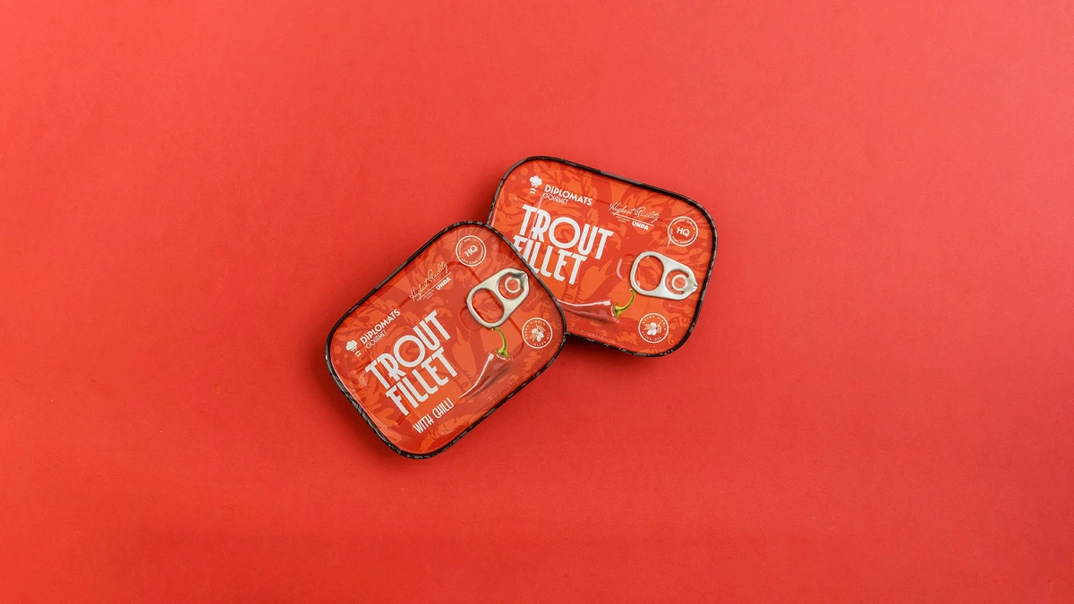 Trout Fillet chilli tins tilted together on plain red background