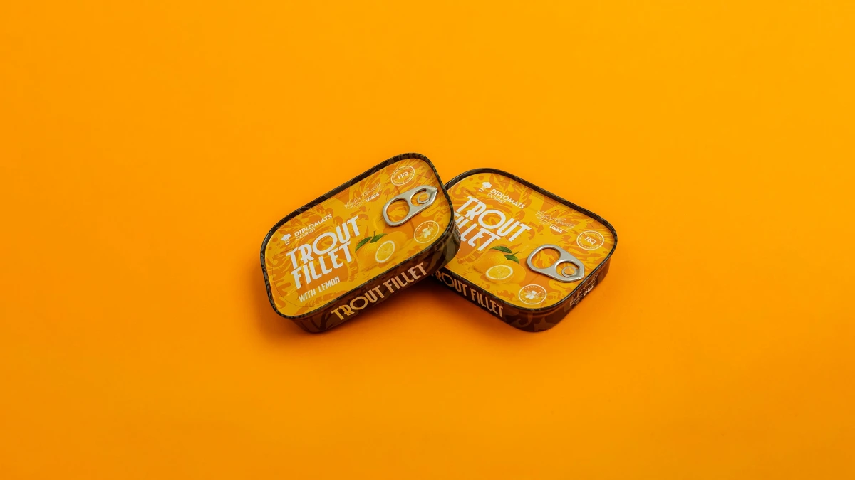 Trout Fillet lemon tins tilted together on plain orange background