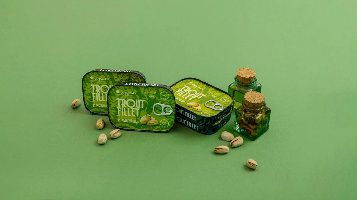 Trout Fillet pistachio oil tins beside two corked oil bottles and pistachios