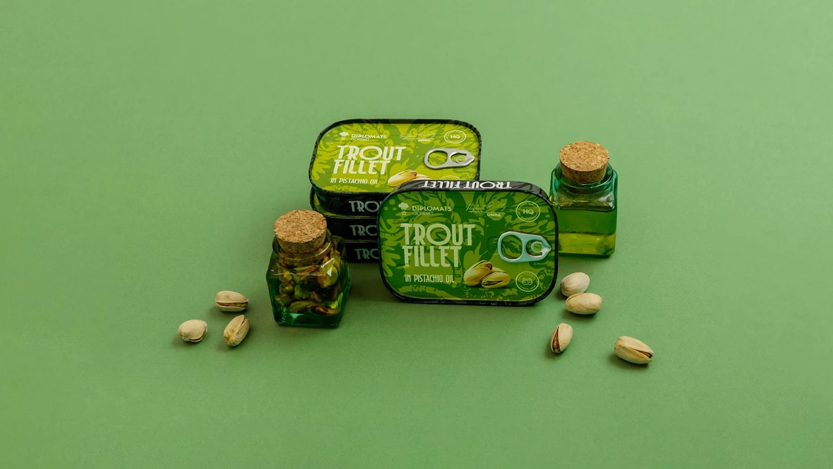 Trout Fillet pistachio oil tins flanked by two corked bottles and pistachios