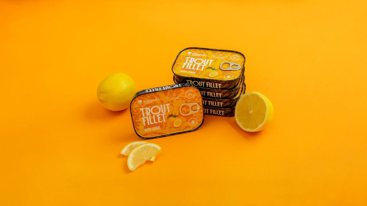 Trout Fillet with lemon tins stacked beside whole and sliced lemons