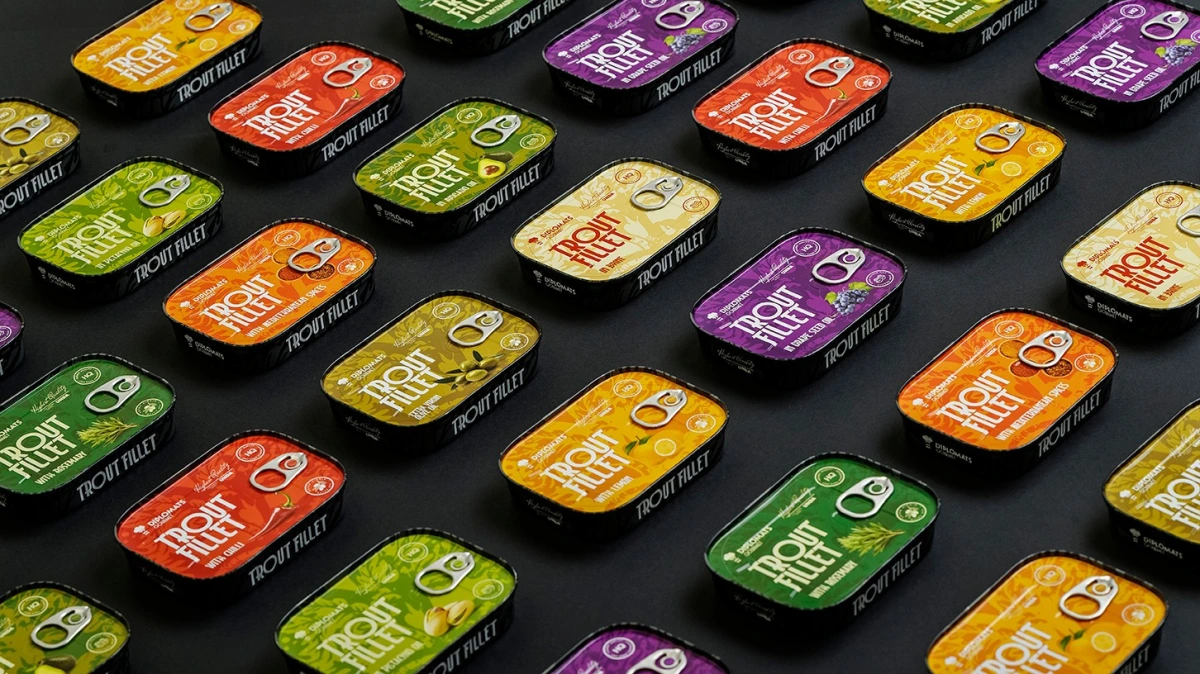 Trout Fillet tins in many flavours arranged diagonally on black background
